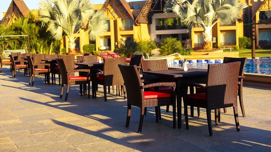 outdoor sitting area with tables and chairs by the pool at Jagira Ananta Elite