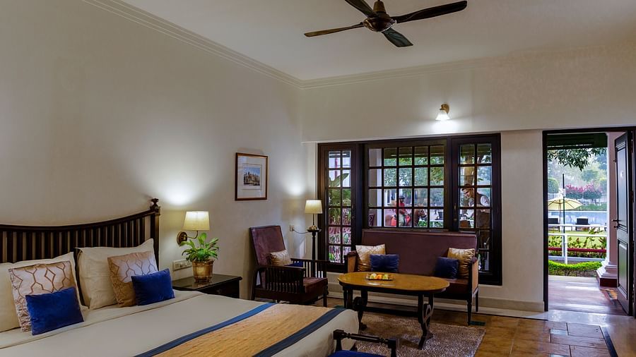 Imperial Room featuring plush bed with furniture in ambient warm lighting with a huge window in the background