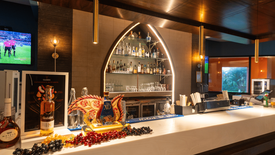 Sleek bar counter featuring an arched liquor display shelf at Kenilworth Resort & Spa, Goa.
