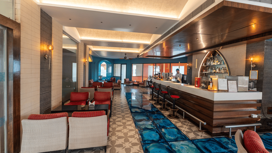 Long lounge corridor featuring a modern bar counter and armchair seating at Kenilworth Resort & Spa, Goa.