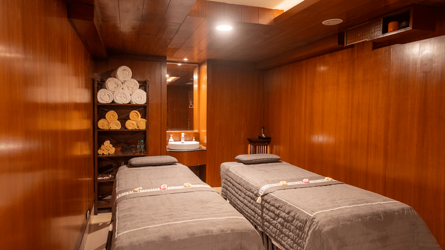 Wooden-panelled couples therapy suite with dual massage beds at Kenilworth Resort & Spa, Goa.