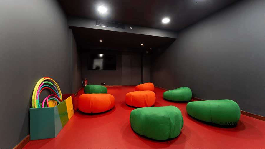 Modern activity room with dark walls and colourful beanbag seating at Kenilworth Resort & Spa, Goa.