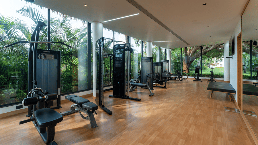 Spacious fitness center equipped with multi-station strength training machines at Kenilworth Resort & Spa, Goa.