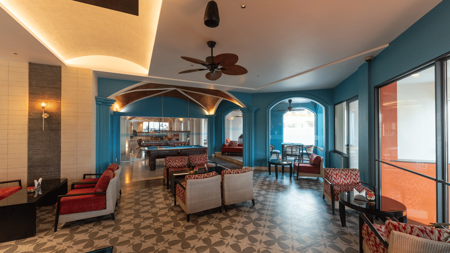 Spacious game lounge with tiled flooring and teal arches at Kenilworth Resort & Spa, Goa.