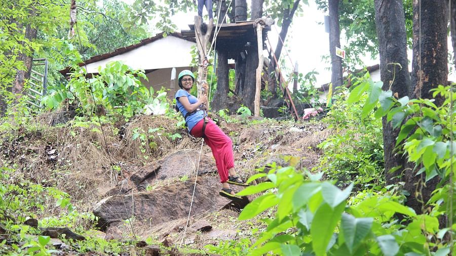Zipline - Kundalika - A  woman riding down the zipline and posing for a picture.