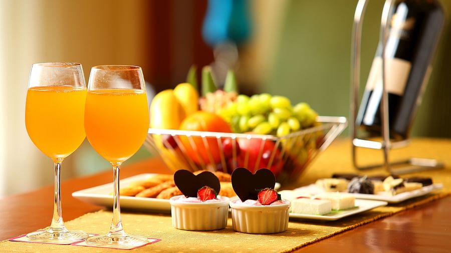 table of two drinks, fruits and desserts