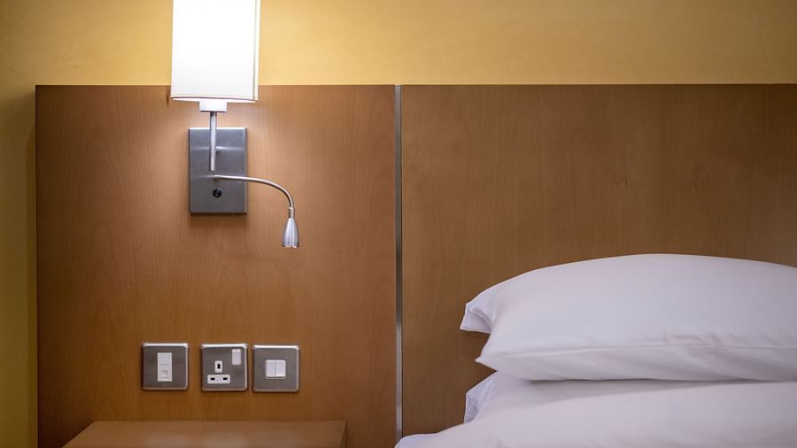 Close up shot of a bed headboard and the lamp hung above the sockets - La Maison Hotel, Doha