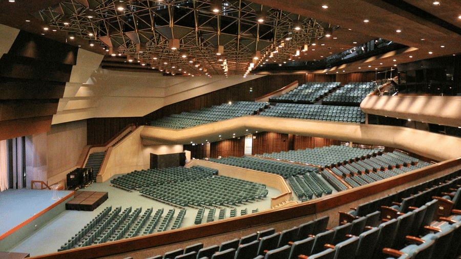 A view form the top of a convention centre with U-shaped seating arrangements and a platform in the centre.