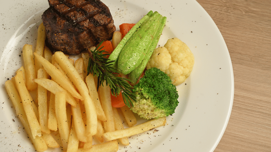 Grilled steak with chips, broccoli, baby corn and fresh vegetables at La Maison Hotel, Doha.