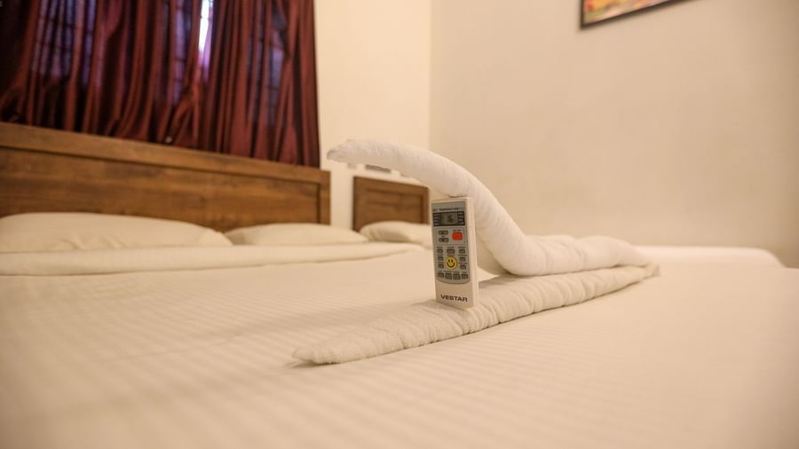 Eye view of a plushy bed  and folded towel in a shape and a wall  at La  Paradise Residency , Pondicherry