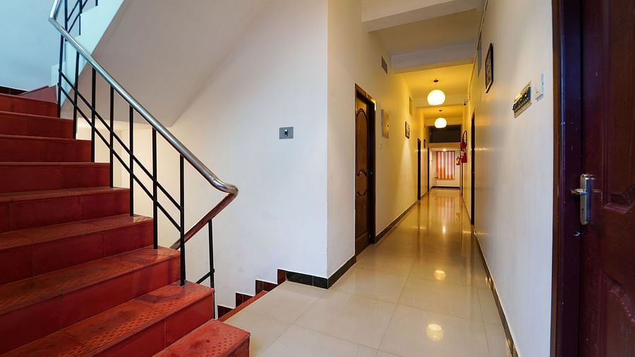 A pathway in the hotel that is edged by rooms on either side and has a staircase to go upstairs | La Paradise Residency, Pondicherry