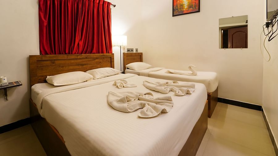A side view of the bedroom with a double bed and a futon with bedding | La Paradise Residency, Pondicherry