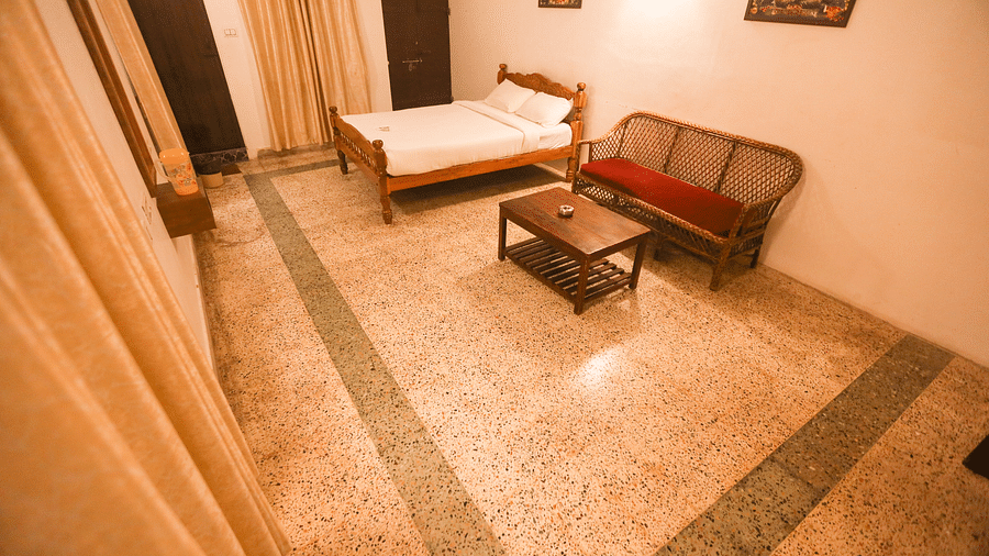 A corner view of the with comfy bed and sitting area at la villas Heritage, pondicherry