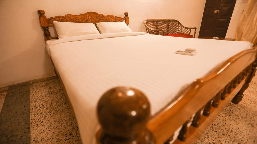 eye level view of the wooden furnished and plushy bed - la villas Heritage, pondicherry