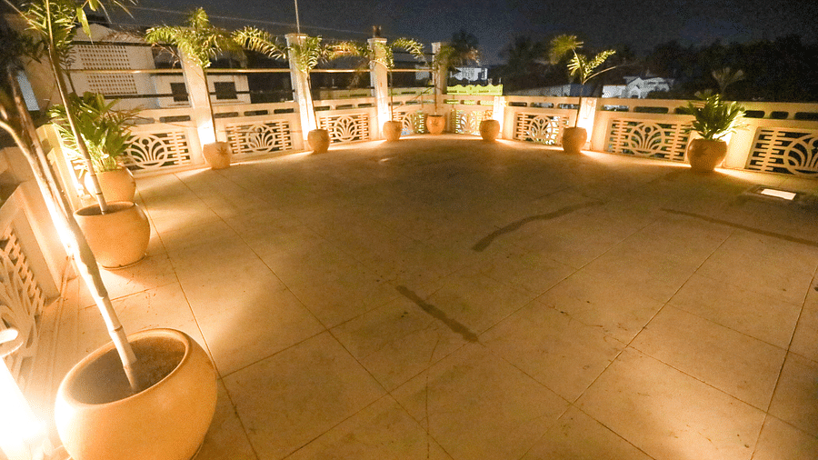 A wide angle view of the terrace during the night time and the terrace decorated with plant and light at The steps from the terrace leading down to the villa covered in red oxide - La Villa Heritage, Pondicherry