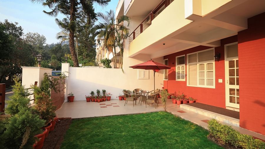 An image of a lawn surrounded by some flower pots and plants near the Lamrin Boutique Cottages Rishikesh building