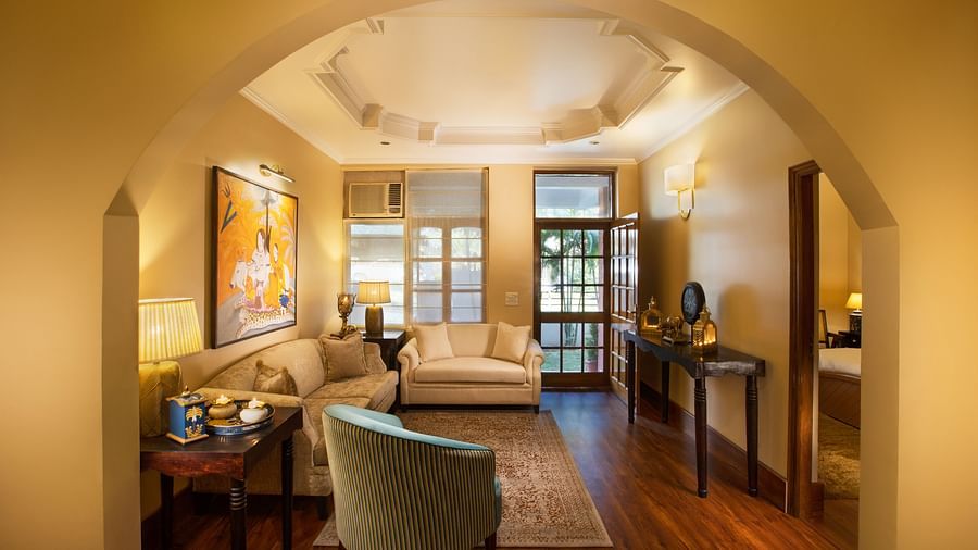 An image of a living room features comfy sofas, large windows, wall paintings, and other decorative items - Lamrin Boutique Cottages Rishikesh