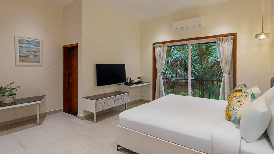 Deluxe room featuring cozy bed, TV unit, and modern interiors at Lamrin Morjim Goa.
