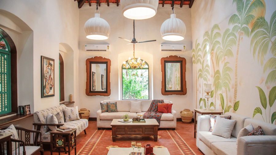 A living area with sofas and centre tables, photo frames on the wall, tables on each corners where decorative items are placed at Lamrin Ucassaim Hotel, Goa