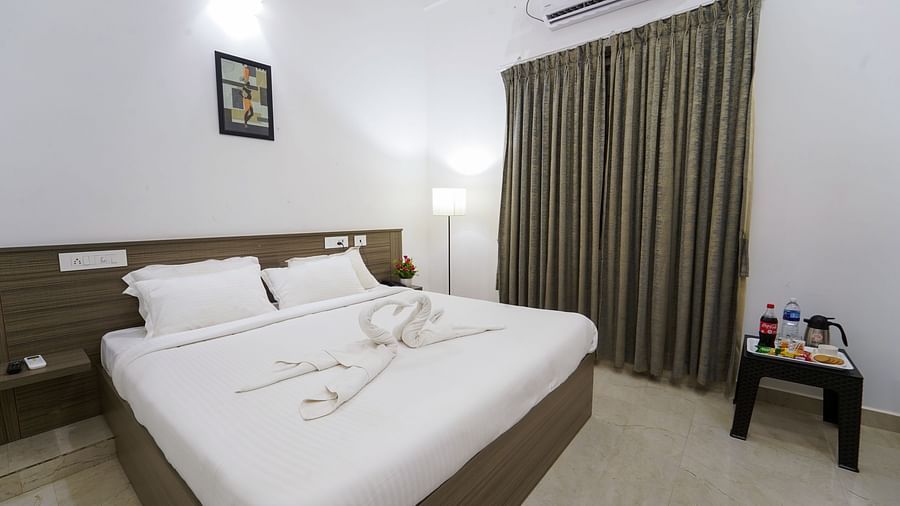 A double bed with an AC wall mounted and a painting above the bed inside Double Deluxe Room - Le Poshe Beachview Pondicherry