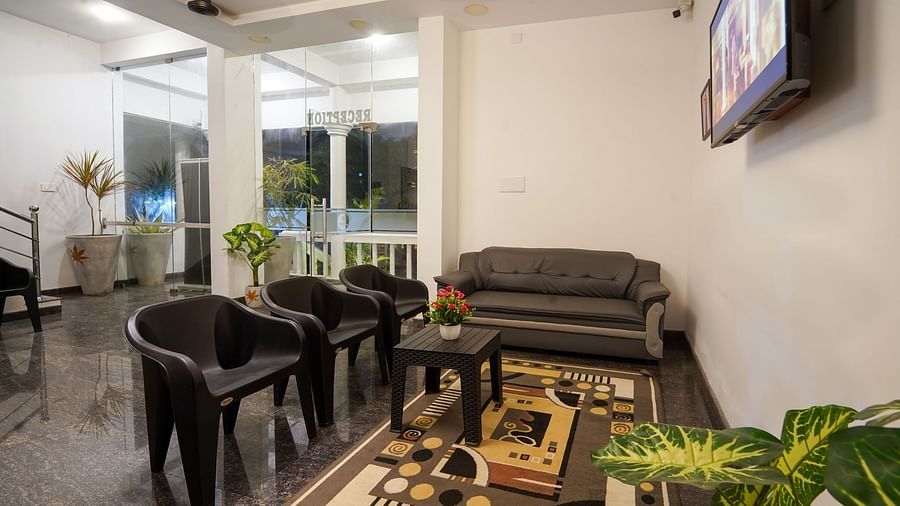 Seating area near the reception with a sofa and plastic chairs - Le Poshe Beachview Pondicherry