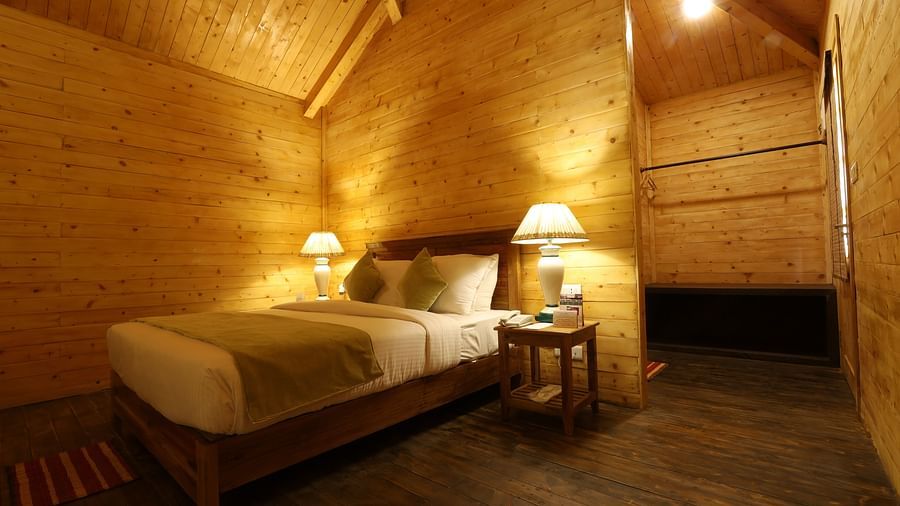 A spacious cosy room with single comfy bed and table lamps at lotus Eco Beach resort konark