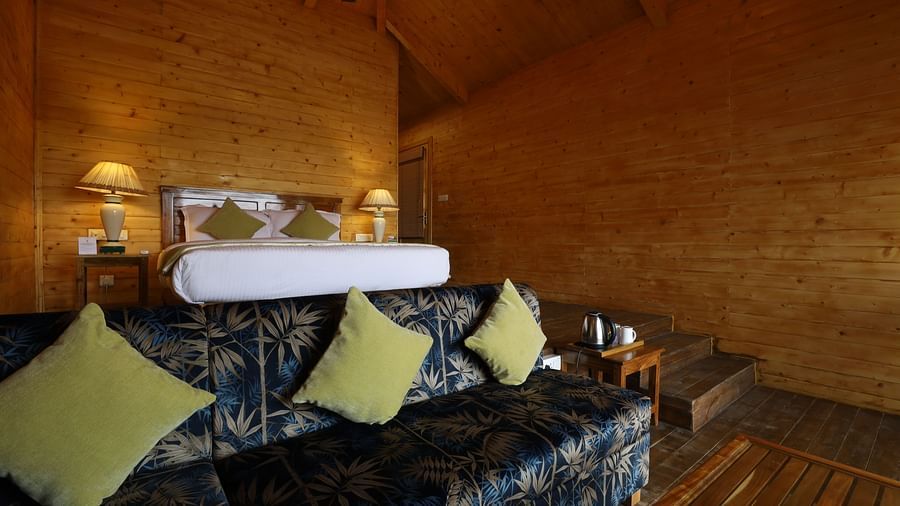 A close up shot of sofa and bed of a cosy room at Lotus Eco Beach Resort Konark.