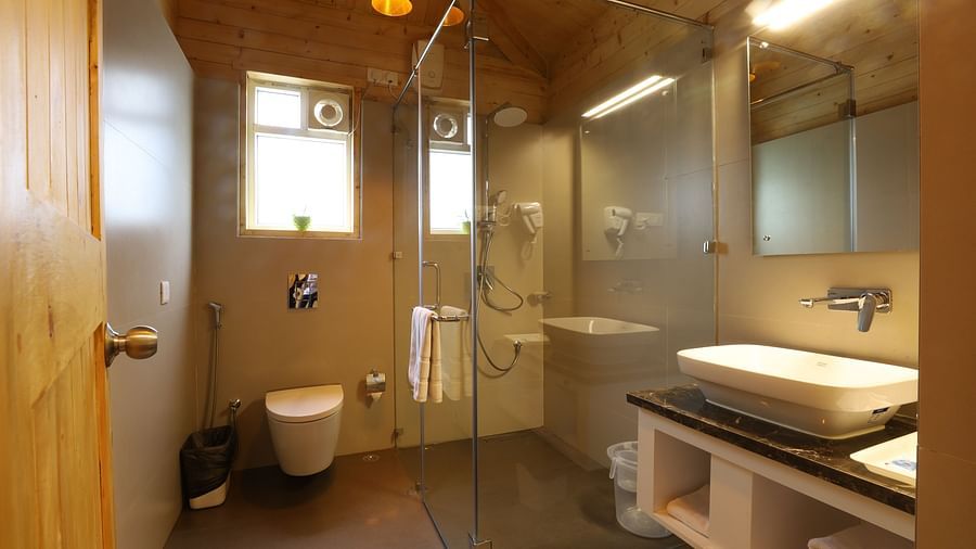 An elegant attached bathroom with wooden furnished and modern facilities at Lotus Eco Beach Resort Konark 