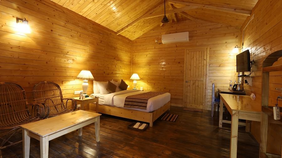 A side view of  a rustic and cosy room at Lotus Eco Beach Resort Konark, with wooden interiors, soft lighting, and comfortable bedding, creating a warm and inviting atmosphere for relaxation.