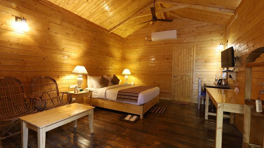 A side view of  a rustic and cosy room at Lotus Eco Beach Resort Konark, with wooden interiors, soft lighting, and comfortable bedding, creating a warm and inviting atmosphere for relaxation.