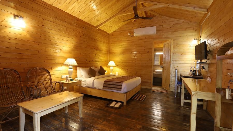 A side view of  a rustic and cosy room at Lotus Eco Beach Resort Konark, with wooden interiors, soft lighting, and comfortable bedding, creating a warm and inviting atmosphere for relaxation.
