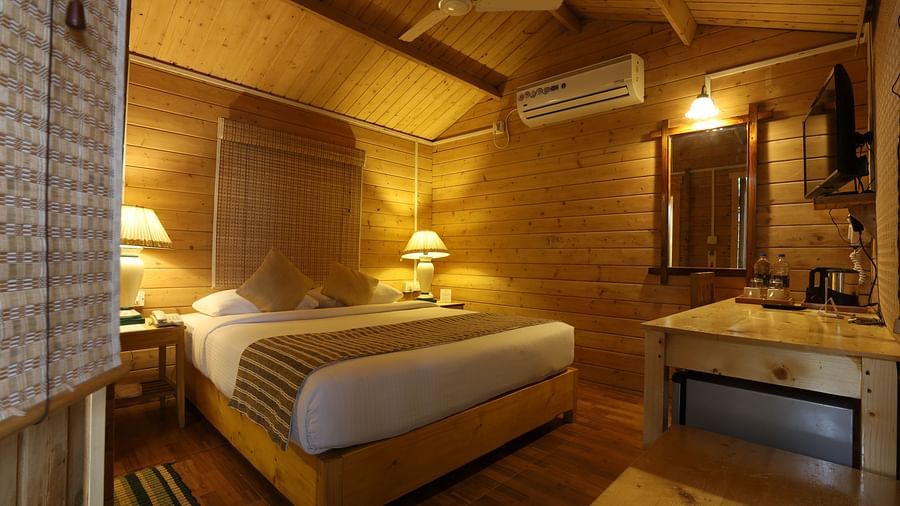 A comfy room with plushy bed, table lamp, AC - Lotus Eco Beach Resort Konark