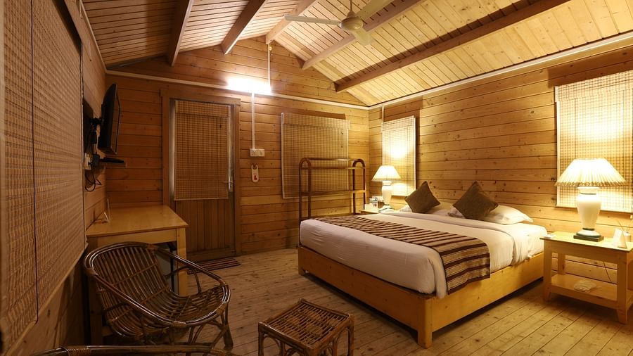 A side view of  cosy room with comfortable bed and wooden furnished - lotus Eco Beach Resort Konark