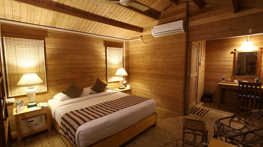 A cosy room with comfortable bed and wooden furnished - lotus Eco Beach Resort Konark