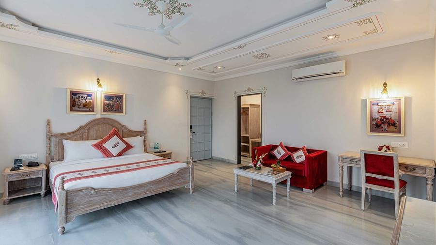 An overview of the suite with a king bed, side tables, coffee table and sofa at Maan Vilas Suite - Maan Vilas by Stone Wood, Udaipur