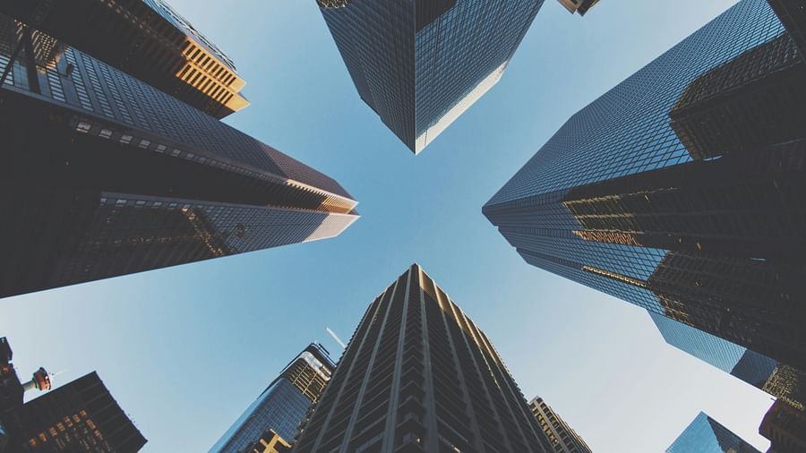 many high rise buildings in view from below with blue sky in the background