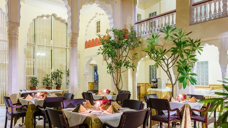 Outdoor seating next to potted plants in the evening at Hari Mahal - Mandawa Haveli, Jaipur