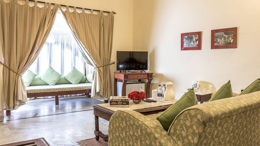 Seating arrangements next to the window with a tv, sofa and coffee table in view inside Standard rooms - Mandawa Haveli, Jaipur
