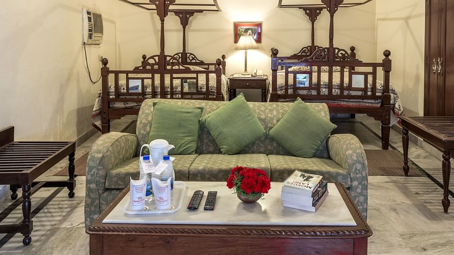 Twin beds in the background with a sofa and a coffee table in front of it inside Standard rooms - Mandawa Haveli, Jaipur