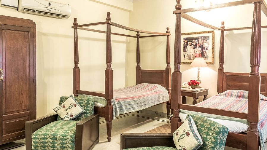 twin beds with single seater sofas in front of it inside Standard rooms - Mandawa Haveli, Jaipur