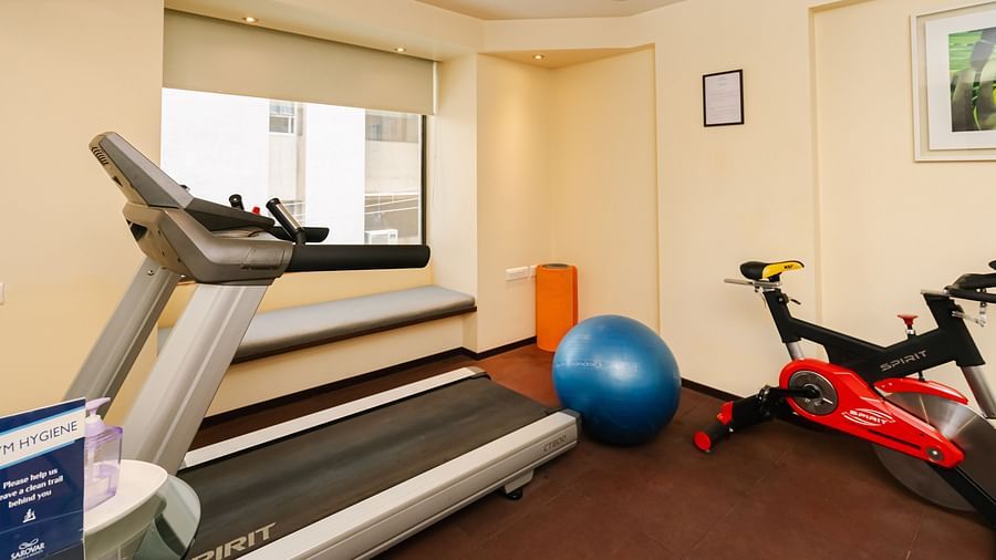 A side angle view of the gym with treadmil, ball and other gym equipment at Marasa Sarovar Portico, Rajkot  