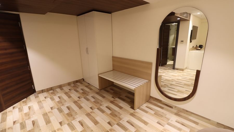 Luggage Area with oval shaped mirror and cabinet as well as luggage bench - Mastiff Hotel, Dhanbad