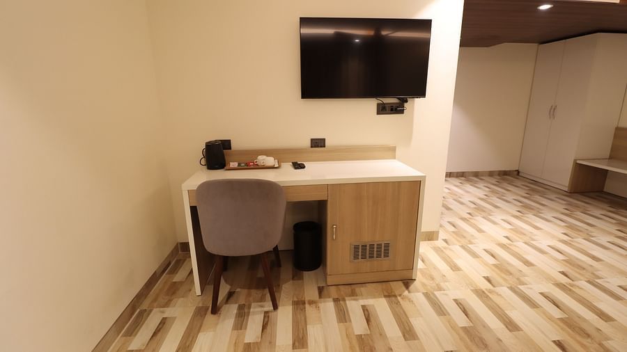 Study Table with TV and chair with wooden flooring in Studio Room - Mastiff Hotel Dhanbad 