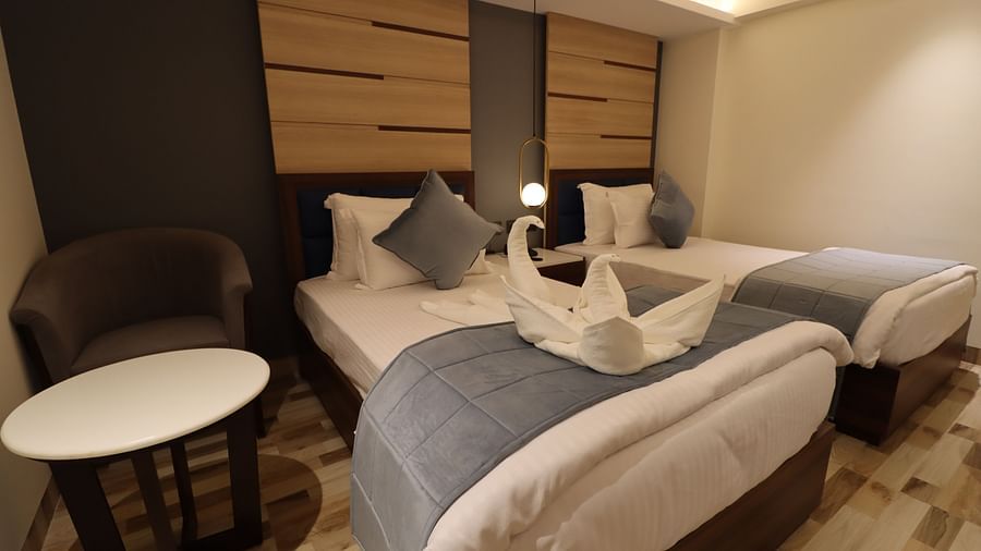 Side angle view of the Superior Twin room with a coffee table on the side - Mastiff Hotel, Dhanbad