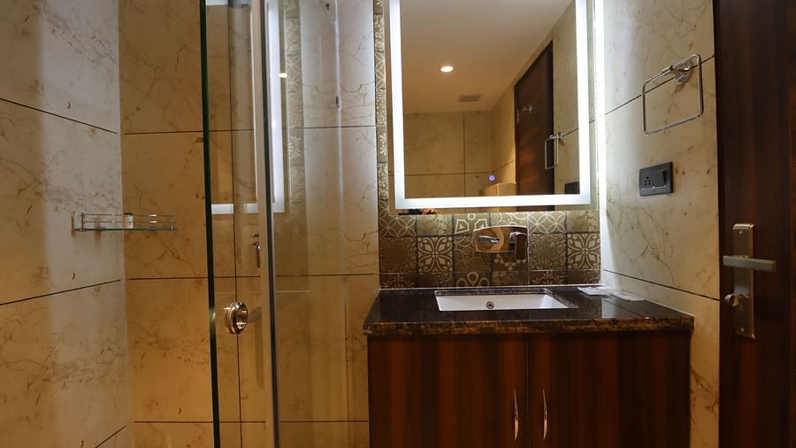 Front view of the Washroom with modern interior design and shower head, cabinet and mirror 