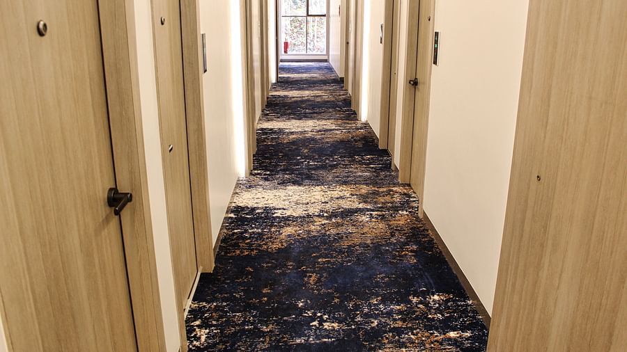 Corridor of hotel with black carpet at Maxxvalue Hotel MIDC,  Mumbai
