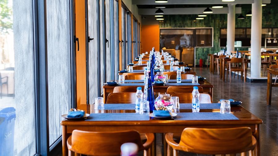 Window-side dining setup at Song of the Sea, MGM Beach Resorts – beachfront restaurant with wooden furniture and natural lighting in ECR, Chennai