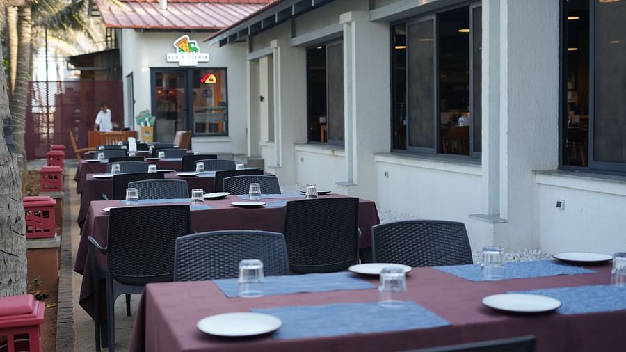 Exterior entrance view of Ezr and Bar with tables and chairs and tiled roof.