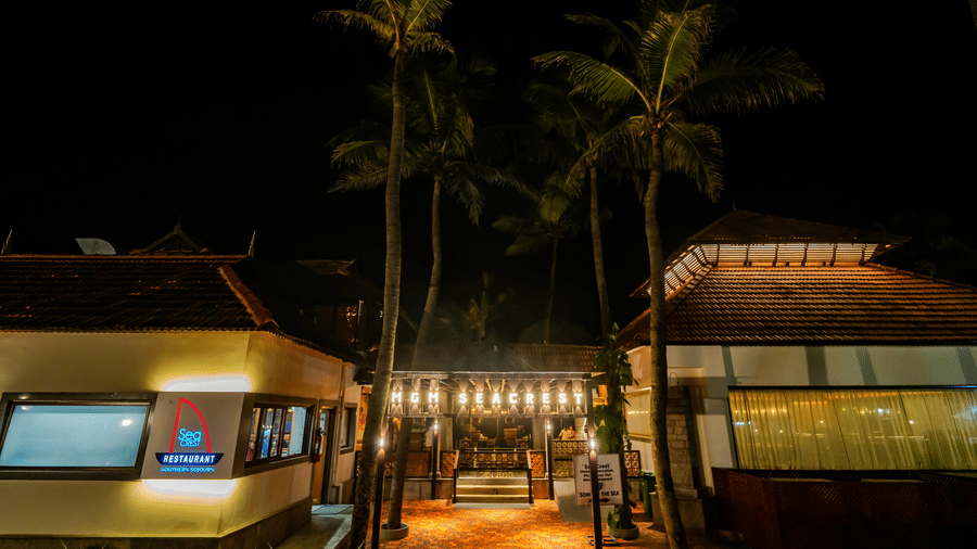 Facade of Sea Crest at MGM Beach Resorts decorated with lights and palm trees on the background.
