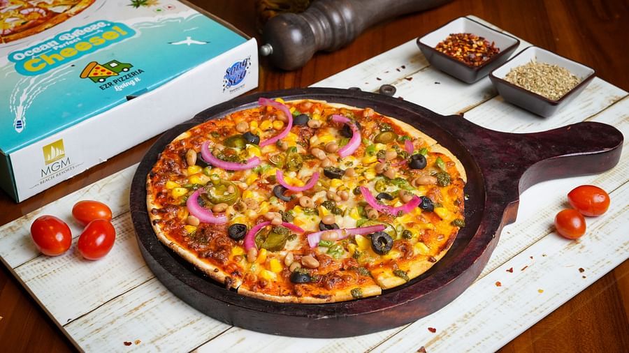 Close-up of a pizza with toppings and packaging box at Ezr and Bar.